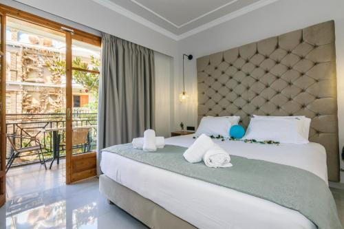 una camera da letto con un grande letto con asciugamani di Plaza Pallas a Tsilivi