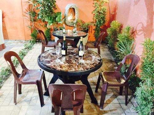 Lindstrom's Inn في بنغلاو: طاولة مع زجاجتين من النبيذ والكراسي
