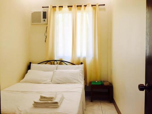 een slaapkamer met een bed en een raam met handdoeken erop bij Lindstrom's Inn in Panglao