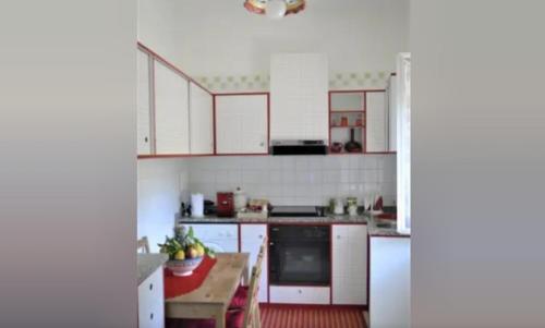 a kitchen with white cabinets and white appliances at A casa di Pissi - apartment in Ravello