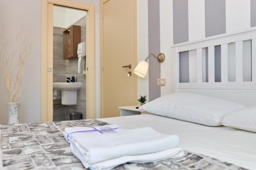 a bedroom with a white bed with towels on it at Criselle in Agropoli