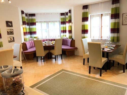 a dining room with a table and chairs and windows at Almtalhotel Appartements in Pettenbach in Pettenbach