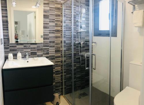 a bathroom with a sink and a glass shower at Modern Studio Lamar Resort in Pilar de la Horadada