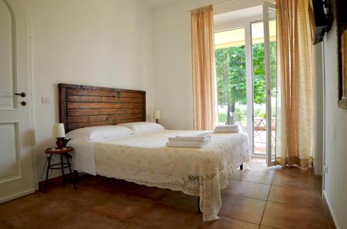 um quarto com uma cama e uma grande janela em Casale Del Gelso em Genzano di Roma