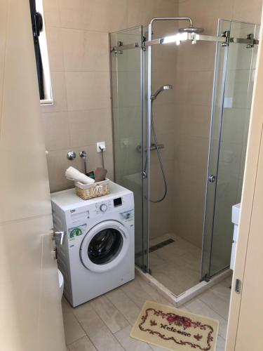 a bathroom with a washing machine and a shower at Mariner 602 in Sutomore