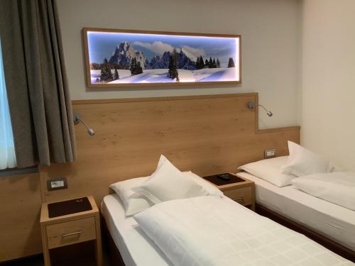 サンタ・クリスティーナ・ヴァルガルデーナにあるガルニ レ シャレーのベッド2台、壁掛けテレビが備わる客室です。