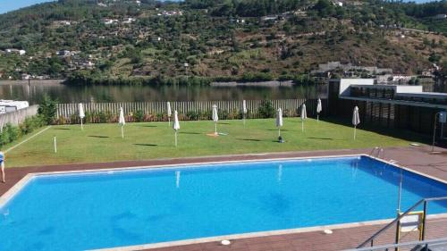 a large swimming pool with umbrellas on top of a building at Alojamento da Ribeirinha in Cárquere
