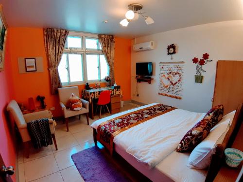 um quarto com paredes cor de laranja, uma cama e uma mesa em Sunny House II em Guilin