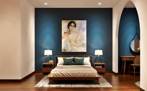 a bedroom with a bed with a painting on the wall at Chez Mimosa Local in Ho Chi Minh City