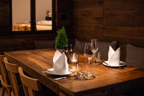 a wooden table with wine glasses and napkins on it at Hotel Tannenhaus in Schöneck