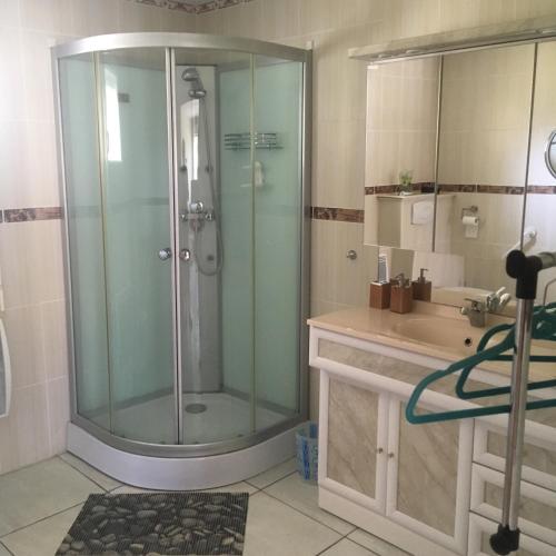 une salle de bain avec une douche en verre et un lavabo dans l'établissement Baie de somme, à Pendé