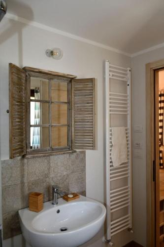 a white bathroom with a sink and a window at Podere Codone in Ficulle