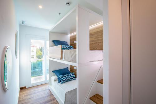 a room with white walls and a staircase with bunk beds at Alcossebre Sea Experience in Alcossebre