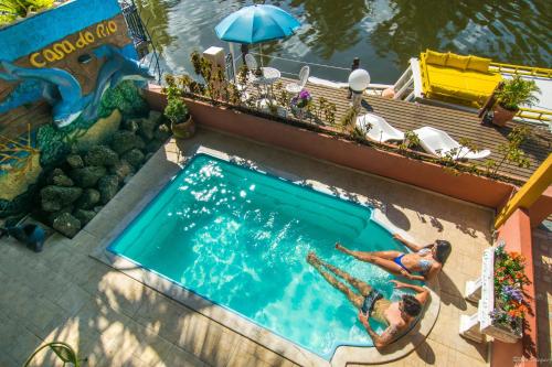 een uitzicht over het zwembad van een resort bij Pousada Casa do Rio Hostel - 8 min do Centro Hístorico - Passeio de Barco com saída da Pousada -Pago a parte- Perto das Praias e Beira Rio in Paraty