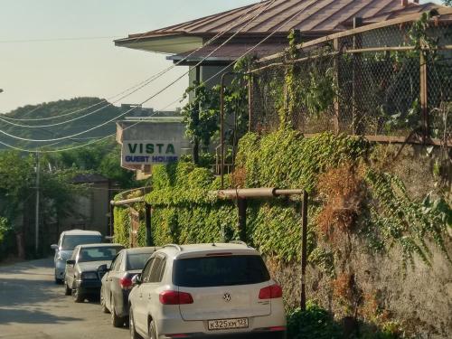 a row of cars parked on a street next to a building at Guest House Vista in Sighnaghi