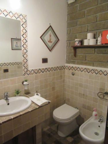 a bathroom with a sink and a toilet and a mirror at Gatto Matto in Manziana