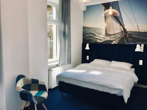 a bedroom with a bed and a picture of the ocean at Apartament Pod Żaglami in Gdynia