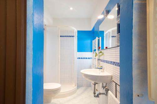 een blauwe en witte badkamer met een toilet en een wastafel bij Dimora Ricceri in Impruneta