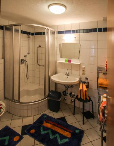 a bathroom with a shower and a sink and a shower at Appartements Sam in Lermoos