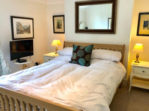 een slaapkamer met een groot wit bed en een spiegel bij Lauras Townhouse Apartments Lansdown Slope Townhouse in Bath