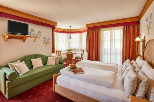 a living room with a green couch and a table at B&B Tamarindo in La Villa