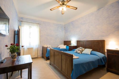 een slaapkamer met 2 bedden en een plafondventilator bij Dimora Ricceri in Impruneta