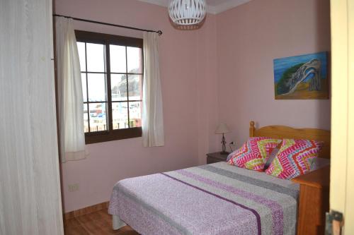 a bedroom with a bed and a window at Junonia Marítimo in Playa de Santiago