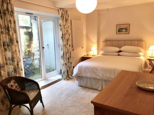 a bedroom with a bed and a window and a table at Lauras Townhouse Apartments Garrard's Retreat in Bath