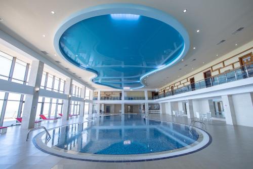 a large swimming pool in a building with a large ceiling at Khazri in Baku