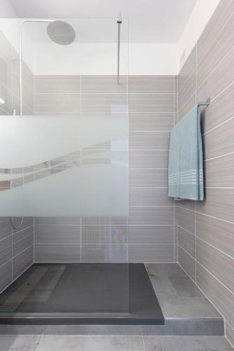 une salle de bain avec une douche avec une porte vitrée dans l'établissement Superbe Marina Spacieuse en face de la Plage!, au Grau-du-Roi