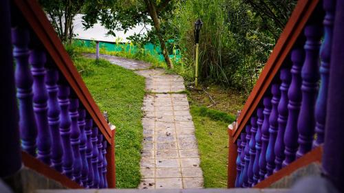 a stone path through a fence in the grass at Joy Source Resort in Kathmandu
