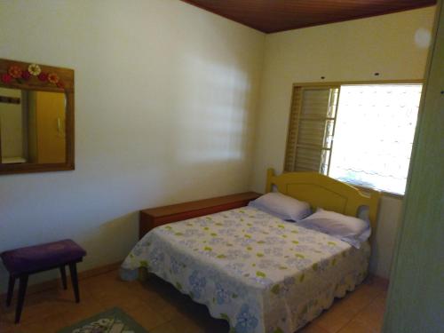 1 dormitorio con cama, espejo y ventana en CHACARA PRIMAVERAS en Jarinu