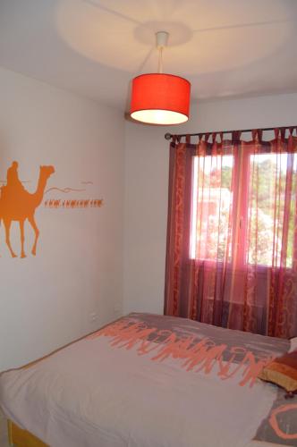 a bedroom with a bed with a camel stencil on the wall at maison zen 60m2 proche Aubenas le Baya in Ucel