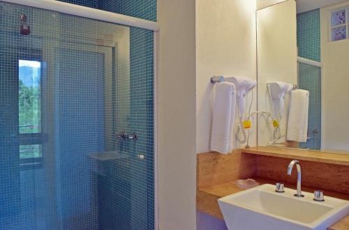 y baño con lavabo y ducha acristalada. en Bella Ilha Pousada en Ilhabela