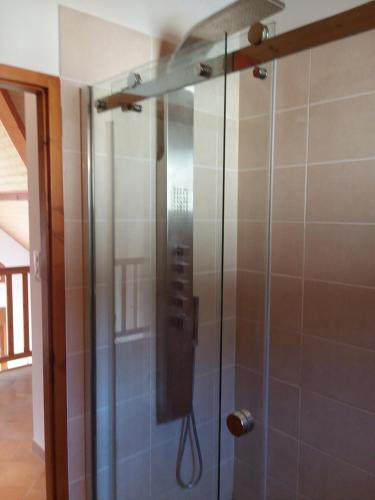 W łazience znajduje się prysznic ze szklanymi drzwiami. w obiekcie Heavens Gate w mieście Saint-Pierre-de-Soucy