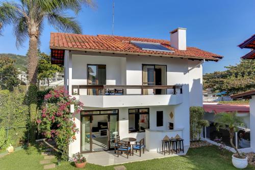 a white house with a table and chairs at Hotel Sete Ilhas in Florianópolis