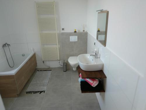 a bathroom with a sink and a tub and a toilet at Studio Red Kot in Zielona Góra