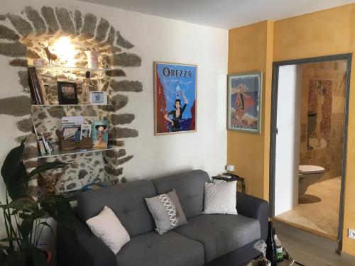 uma sala de estar com um sofá e uma parede de pedra em Chez Marco Gîte & SPA CAPPELLINA em Muro