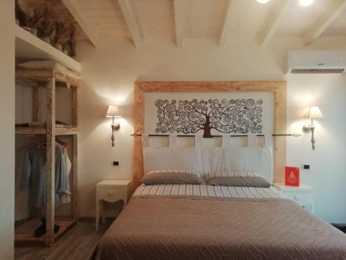 a bedroom with a bed with a tree on the wall at Corte Franca La Nuova Era in Tragliata
