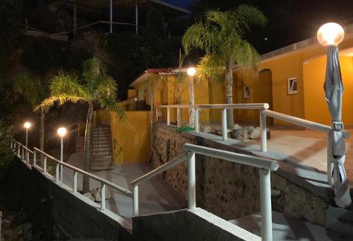 a building with stairs and palm trees at night at Sunrise in Ischia