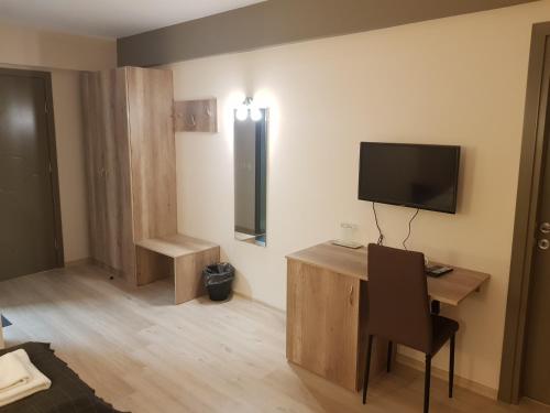 a room with a desk and a tv on the wall at Апартаментен туристически комплекс Аква Терми in Krasnovo