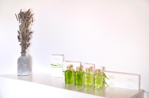 a shelf with four green bottles on it at Blackbird House Štanjel Historic Center in Štanjel