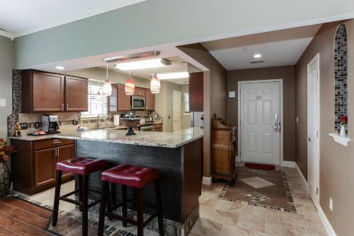 a kitchen with a large counter and two stools at Luxury Condos at Thousand Hills - Heart of Branson - Beautifully remodeled - Spacious and Affordable in Branson