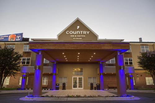 a front view of a building with blue lights at Country Inn & Suites by Radisson, Harlingen, TX in Harlingen
