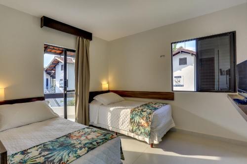 a bedroom with two beds and a window at Hotel Sete Ilhas in Florianópolis