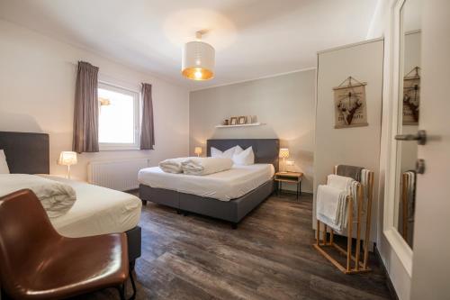 um quarto de hotel com duas camas e uma cadeira em no.dreizehn em Neustift im Stubaital