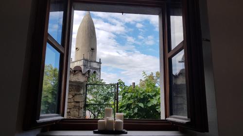 an open window with candles in front of a church at Blackbird House Štanjel Historic Center in Štanjel