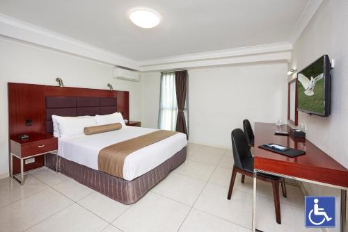 a hotel room with a bed and a desk at Best Western Casula Motor Inn in Liverpool