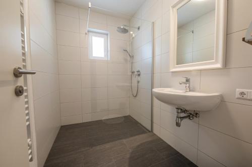 uma casa de banho branca com um lavatório e um espelho em no.dreizehn em Neustift im Stubaital