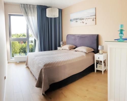 Un dormitorio con una cama grande y una ventana en Apartament North Coast - nad morzem, en Gdansk